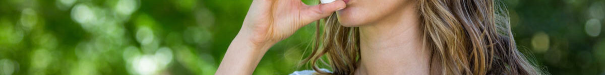 Woman using asthma inhaler