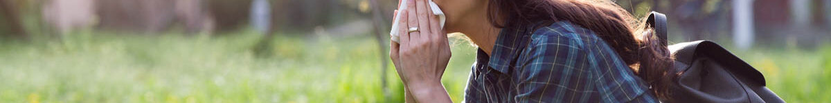 Woman blowing nose because of spring pollen allergy