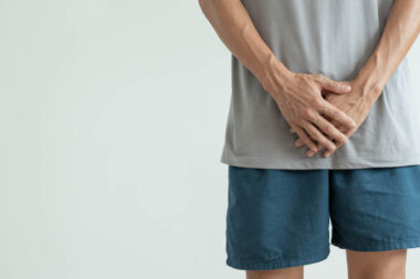 Man hold hand in front of private parts feeling discomfort from