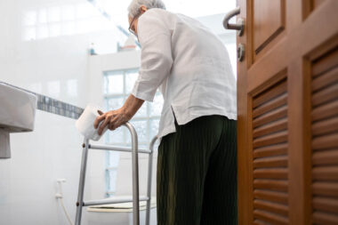 Senior woman with diarrhea holding tissue roll near a toilet bow