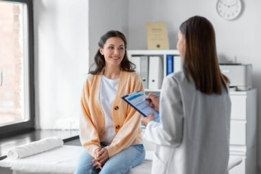 doctor with clipboard and woman at hospital