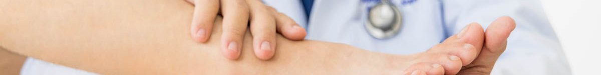 The orthopedic doctor or surgeon in white gown examined the pati