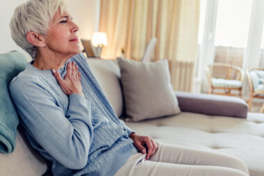 Female with chest pain. Senior woman suffering from heartburn or