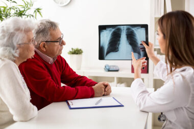 Doctor shows results to old patient x-ray of the lungs