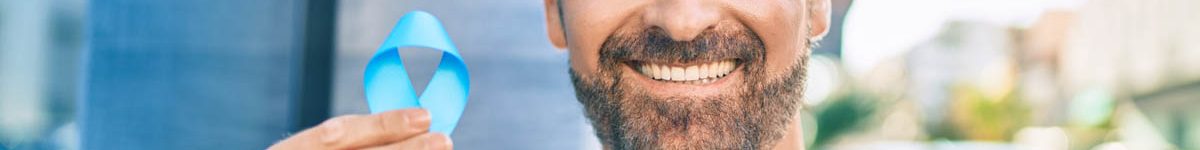 Middle age handsome man smiling happy holding blue prostate cancer ribbon at the city.