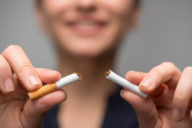 Addiction. Closeup of young attractive woman breaking cigarettes