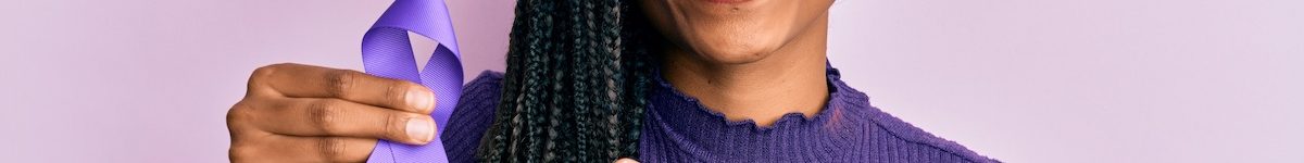 African american woman holding purple ribbon awareness smiling happy pointing with hand and finger